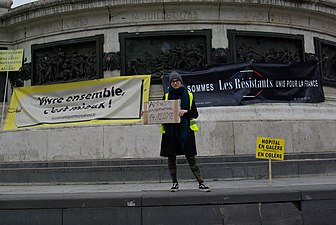 Manifestante invitant à lire le rapport d'Amnesty International sur les violences policières commises pendant le mouvement des Gilets jaunes (29 décembre 2018).
