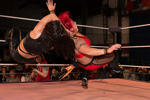 Nikki Storm (left) performing a swinging fisherman's neckbreaker on Lufisto in 2014.