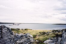 A squid trawler, and a cruise ship in Port William representing two trends in recent economic development Port-William.JPG