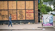 Graffiti on the boarded-up Max It Pawn shop in Minneapolis, May 27, 2020. It was looted and set on fire the following day. Protest and riot aftermath on west Lake Street (49945876698).jpg