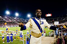 A student drum major conducts the Pride of the Spartans marching band during a football game at Stanford University. San Jose State University Marching Band Drum Major 01.jpg