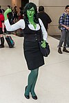 Green skinned woman dressed in a business suit