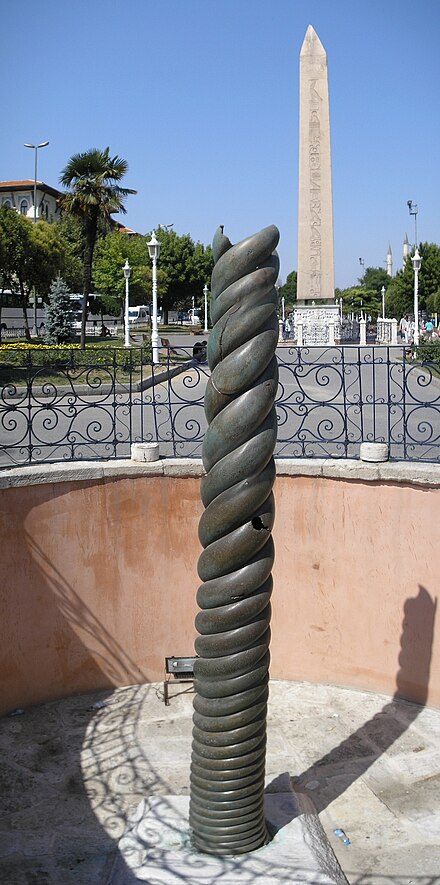The ancient bronze Serpent Column at the Hippodrome of Constantinople. The Obelisk of Theodosius is seen in the background.