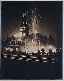 The Sydney Town Hall illuminated in celebratory lights and fireworks marking the Inauguration of the Commonwealth of Australia, 1901. The sign reads One people, one destiny. Town Hall, Sydney, Inauguration of Australian Commonwealth.jpg