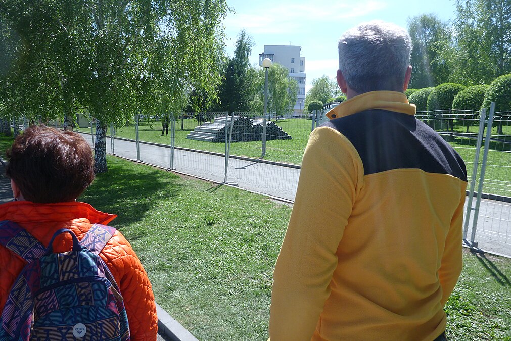 Ерохин и организатор встречи в Екатеринбурге идут мимо забора, который накануне сносили протестующие