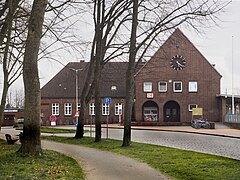 This is a photograph of an architectural monument. Empfangsgebäude mit Vorplatz 53°47′19″N 9°25′44″E﻿ / ﻿Bahnhofstraße 5, 5b﻿ / 53.78854511725269; 9.428794910590339 Baujahr: 1938   Foto: 2023  