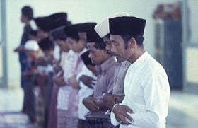 Indonesian Muslim men wearing songkok and sarong standing in salah. COLLECTIE TROPENMUSEUM Moslimmannen tijdens het gebed op vrijdag in de moskee Tulehu TMnr 20017952.jpg