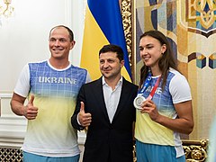 Die Kanuten Anastasiia Chetverikova und ihr Trainer Iurii Cheban mit dem Präsidenten der Ukraine Volodymyr Zelensky.jpg