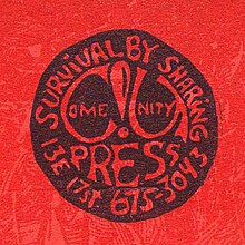 Black circle with negative space showing the Come!Unity press logo, surrounded by the slogan "Survival by sharing" and the address and phone number