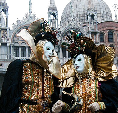 A couple wearing Masks during Carnival in front of the Basilica di San Marco, Venice, Italy