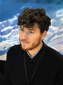 un homme cheveux bouclés avec une barbe.