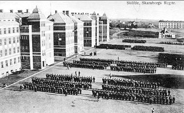 Skaraborgs regemente, Skövde uppställt på kaserngården, öster om kasernbyggnaderna. I bakgrunden (till höger) Livhusarkasernen