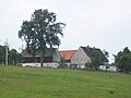 Wohnstallhaus, östliches Seitengebäude, westliche Scheune und Torbogen eines Vierseithofes