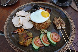 Porción tradicional de nasi goreng con guarnición compleja