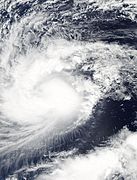 O furtună tropicală cu nori înfășurați în jurul centrului;  o masă de furtuni poate fi văzută concentrată în centru