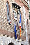 The façade of the city hall with the flags of France, the EU and Catalonia