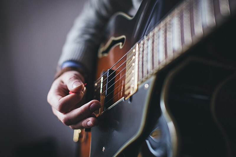 File:Red pick and brown guitar (Unsplash).jpg