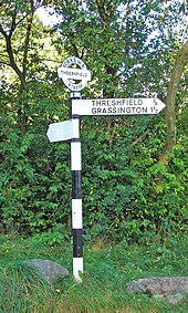 A typical West Riding fingerpost with the parish name and grid reference on the roundel. Signpost near Skirethorns - geograph.org.uk - 1009850.jpg