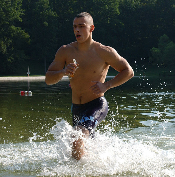 A barechested man running out of the water