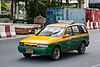 An owner-operated green and yellow Bangkok taxi