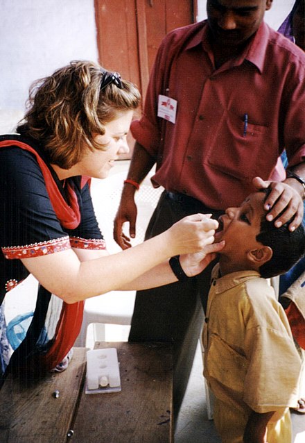 A healthcare worker gives pediatric polio vaccination to a young boy.