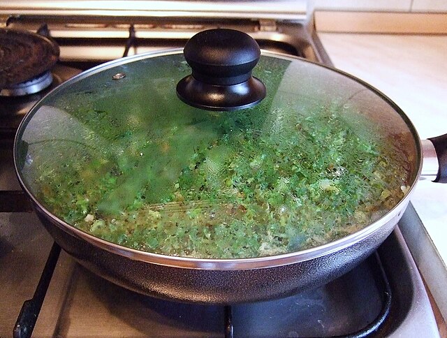 Cooking kuku sabzi (herb kuku) in a pan