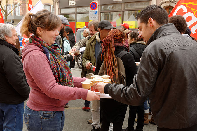 Une participante de l'animation "Luttons contre le gaspillage alimentaire", venant proposer une dégustation à des manifestants.