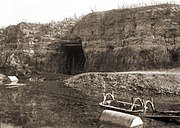 Abbauwand des Tagebaus mit vergittertem Zugang zum Untertagebau, um 1930