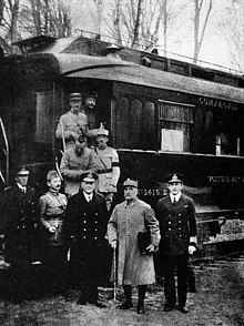 черно-белая фотография пятерых мужчин в военной форме, стоящих бок о бок справа от его железнодорожного вагона № 2419 D в Компьенском лесу. 