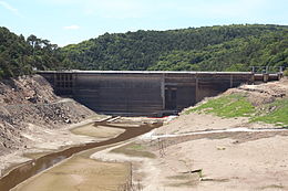 photo du barrage en béton barrant la vallée asséchée