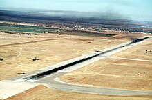 Two C-130 Hercules aircraft of the 463rd get airborne as the remaining 16 aircraft wait on the runway during a Minimum Interval Takeoff at the start of a mass airdrop exercise at Dyess DF-ST-91-05741.jpg