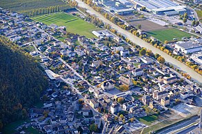 Villaggio visto dall'alto accanto a un fiume.  Le strade e le case sono facilmente distinguibili.