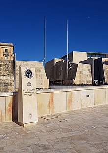 Lapida fid-daħla tal-Belt Valletta b'iskrizzjoni dwar meta tniżżlet bħala Sit ta' Wirt Dinji mill-UNESCO