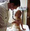 Doctor uses a stethoscope to examine a young patient.JPEG