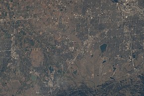 View of the eastern and southern borders of Boulder County and adjacent areas in Weld, Broomfield, and Jefferson counties, with north oriented to the left. The city of Boulder is near the lower border. Taken from the International Space Station on July 1, 2022.