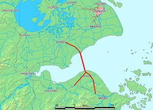 Hangzhou Bay extends from the East China Sea (right) to its namesake, the city of Hangzhou, where the Qiantang River flows in (lower left). The red line shows the first bridge crossing of the bay, Hangzhou Bay Bridge. Zhoushan Islands is the archipelago, off Ningbo, at the southeast edge of the Bay (lower right).