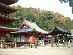 Wooden building with white walls, red beams and a hip-and-gable roof.