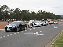 A motorcade transporting senior members of the official party to an event in Canberra on 21 November 2009. The black car, at left, with the number plate ADF1, carried the Chief of the Defence Force; the white car behind it, with the number plate C1, carried the Prime Minister; and the black car, second from the right, carried the Governor-General. Official convoy Op Catalyst Welcome Home Parade.JPG
