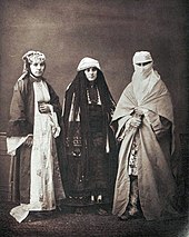 photographie noir et blanc : trois femmes en costume traditionnel.lÁ gauche, une femme juive de Salonique, 1873.