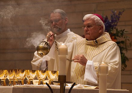 John Michael Quinn, Bishop of Winona-Rochester, swinging a thurible over the offering at Mass