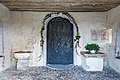 English: Romanesque portal, stoup and lapidarium at the porch Deutsch: Romanisches Portal, Weihwasserbecken und Lapidarium in der Turmvorhalle