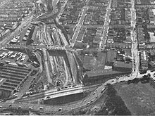 Freeway construction on the former Southern Pacific right-of-way in 1964. The Elkton shops are at left, with Ocean Avenue in the foreground. Southern Freeway construction at Balboa Park, 1964.jpg