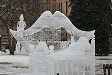 Une sculpture de glace représentant une bouche ouverte et une petite fée assise dessus