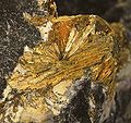 Wakabayashilite: Arsenosulphide of Arsenic and Antimony: exposure of radiating, acicular, golden crystals