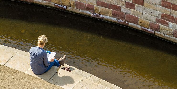Lesende Frau an einem Bach. Reading woman on a stream.