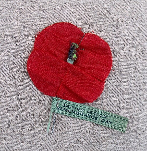 1921 British remembrance poppy. Cotton and silk poppies were made in devastated areas of France by Madame Guérin, "The Poppy Lady from France" and the