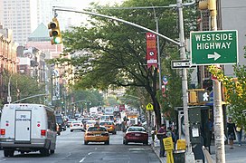 A typical traffic light on Ninth Avenue in New York City. Note that the traffic light gantry is of a guy-wire masted style, which is unique to New York City.