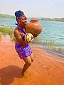 An Igbo lady lifting her pot of water