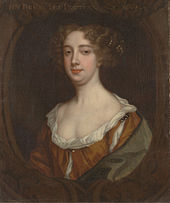 Portrait of woman with should length curly black hair and pearl necklace