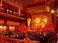 Inside of the Hundred Dragon Hall, showing a seated Buddha Maitreya flanked by two Bodhisattvas